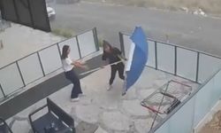 Genç çalışanın şemsiye ile imtihanı kamerada