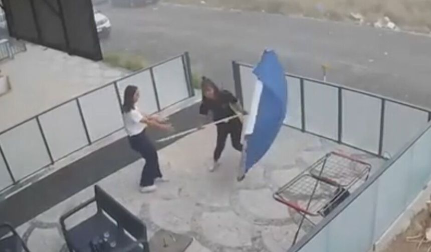 Genç çalışanın şemsiye ile imtihanı kamerada